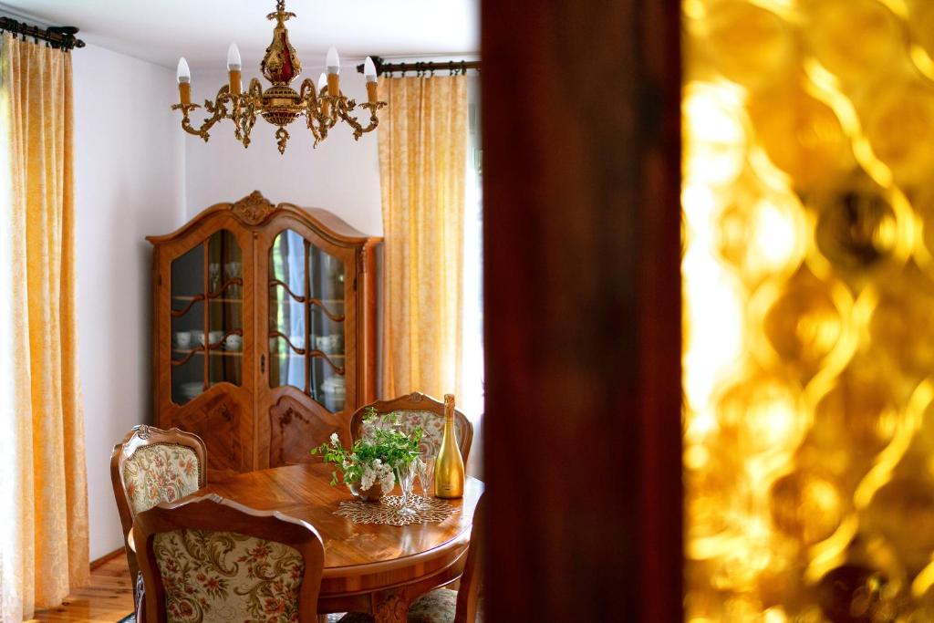 une salle à manger avec une table, des chaises et un lustre dans l'établissement Dom z widokiem na Park, à Nałęczów