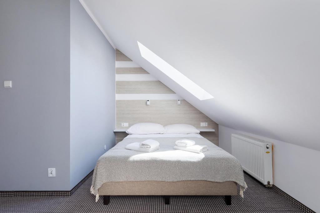 ein Schlafzimmer mit einem Bett mit zwei Handtüchern darauf in der Unterkunft Willa Arielka in Rewal