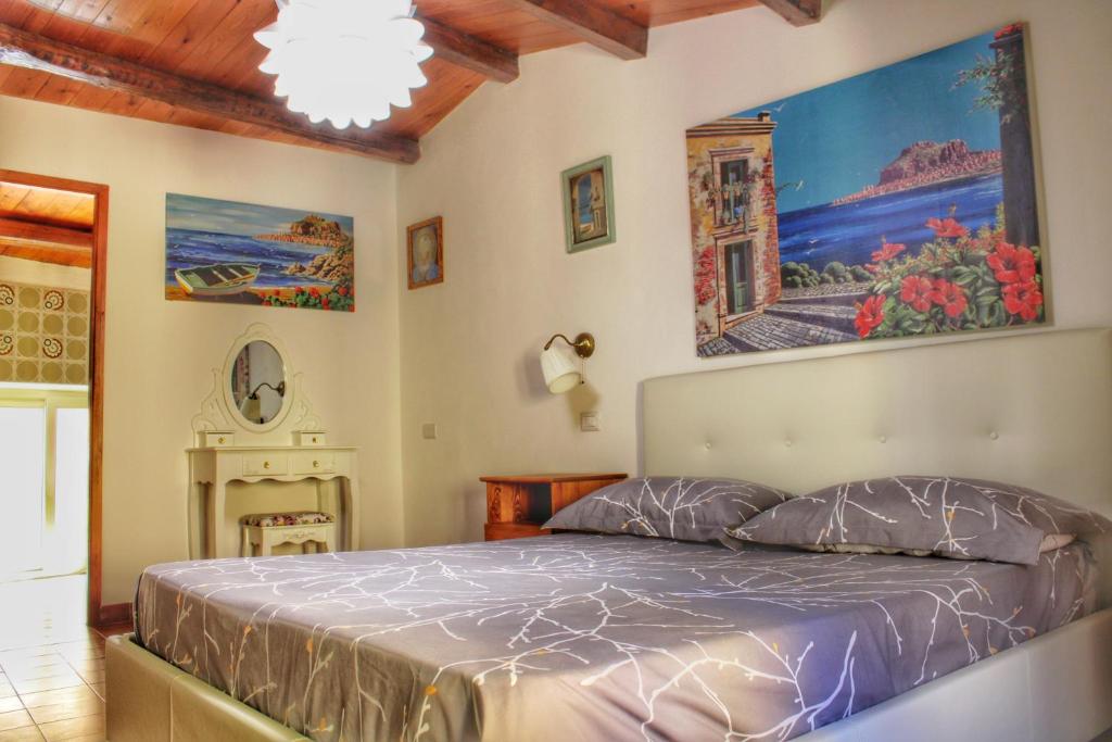 a bedroom with a bed and a painting on the wall at Gerani House in Cefalù