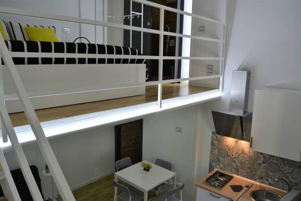 Habitación con cama elevada y escritorio. en Dock78 - MiniLoft in Catania Center en Catania