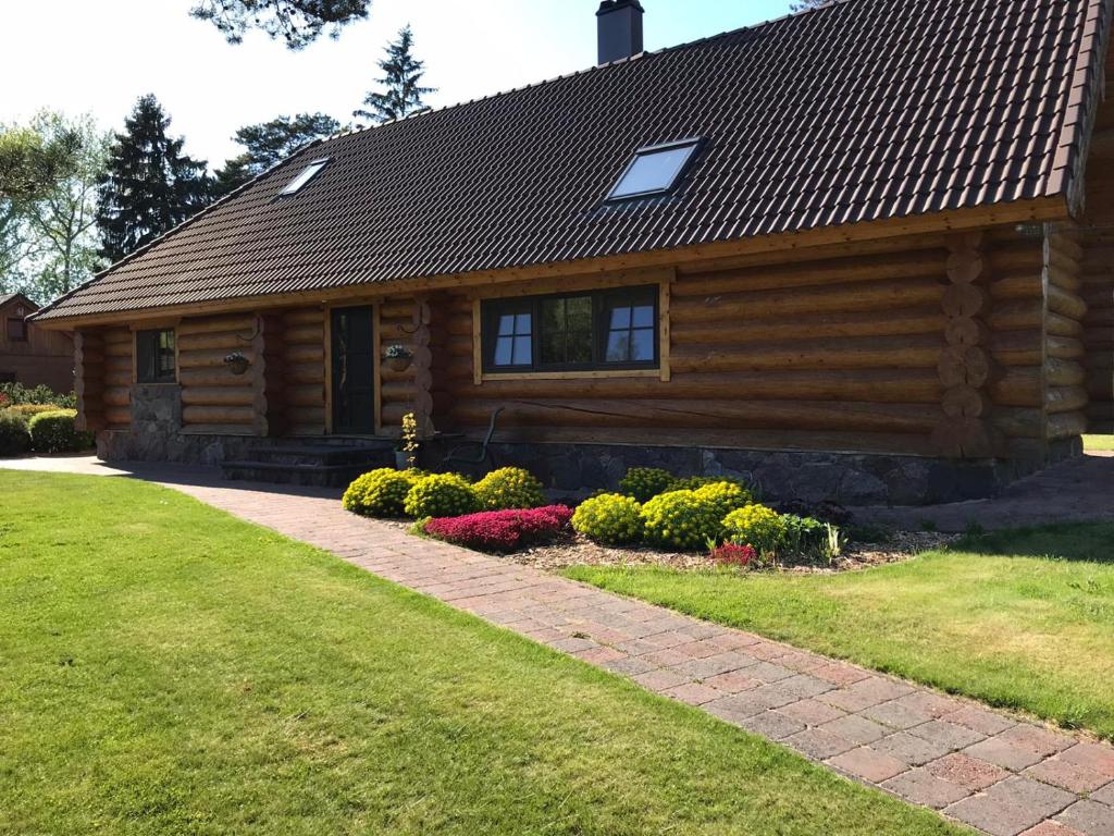 a log cabin with flowers in front of it at The gorgeous log house, that brings out the smile! in Hara