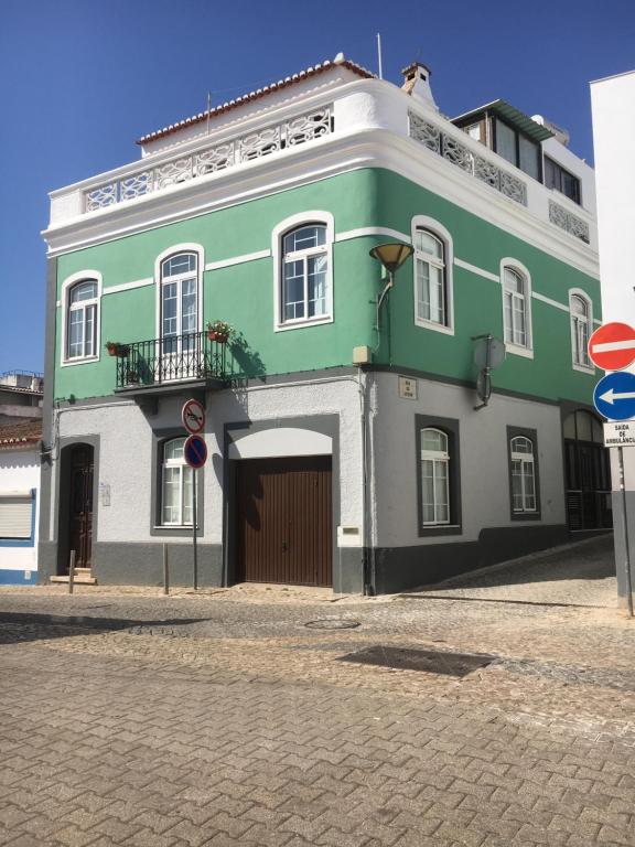 a green and white building on a street at Casa das Netas in Lagos