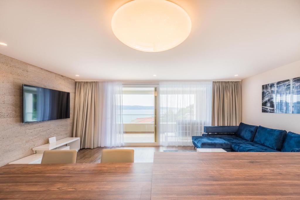 a living room with a blue couch and a tv at Apartment Olijfboom in Dugi Rat