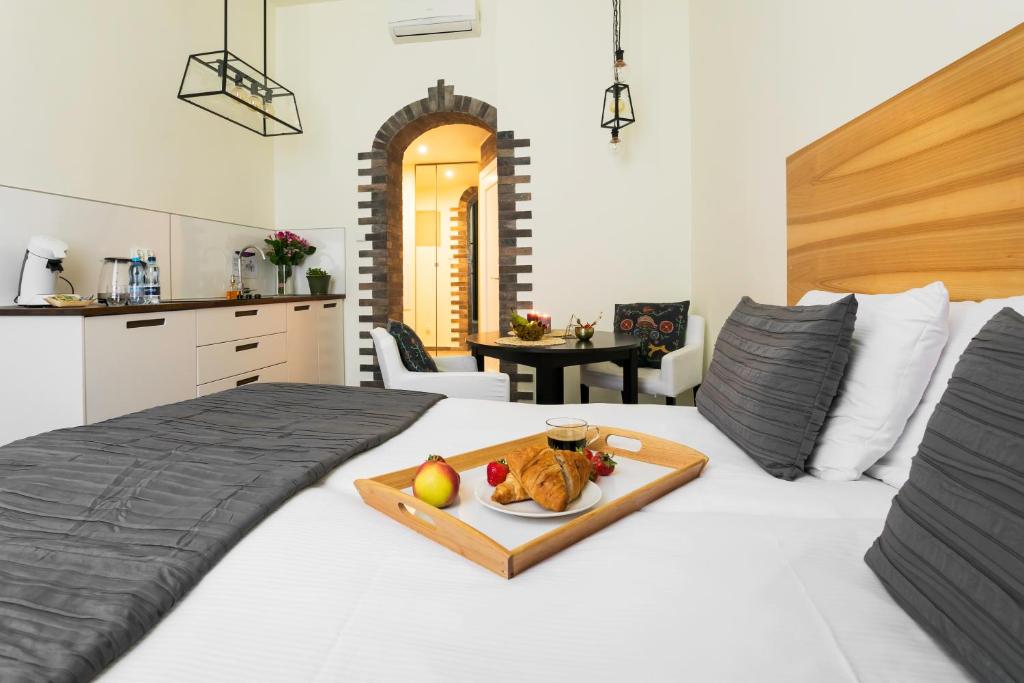 a white bed with a tray of food on it at Platinum Suites in Kraków