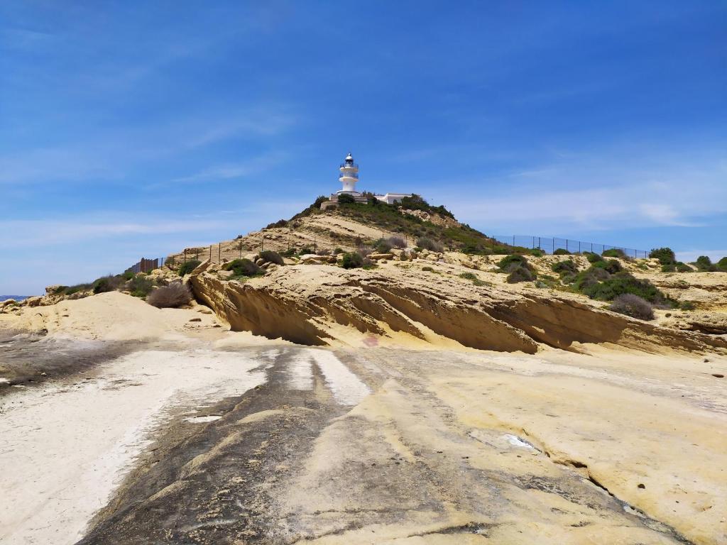 アリカンテにあるLa Casita del Faroの坂の上に灯台のある未舗装道路
