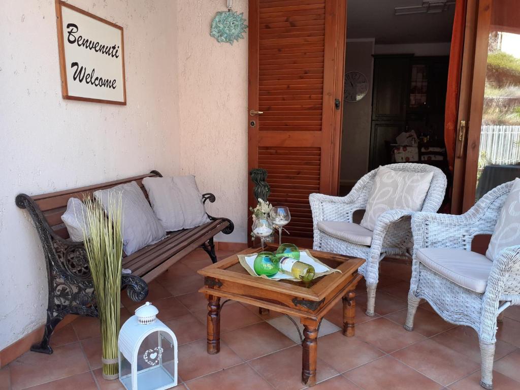 un portico con panchina, sedie e tavolo di Bilocale centrale con veranda a pochi metri dalla spiaggia a Castelsardo