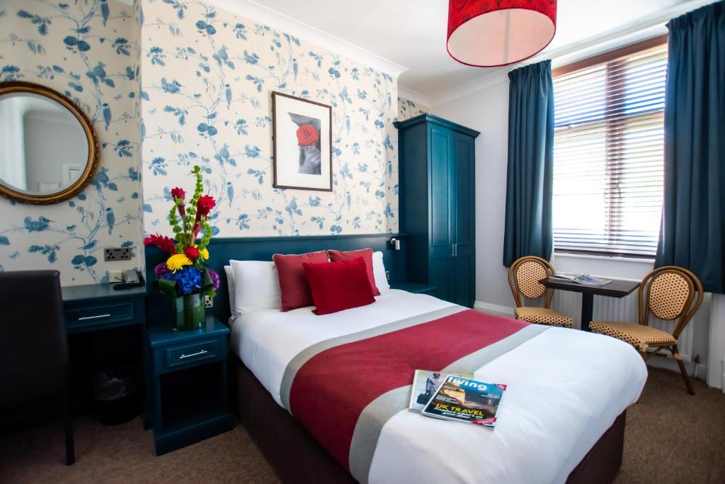 um quarto de hotel com uma cama e um espelho em New Steine Hotel - B&B em Brighton & Hove