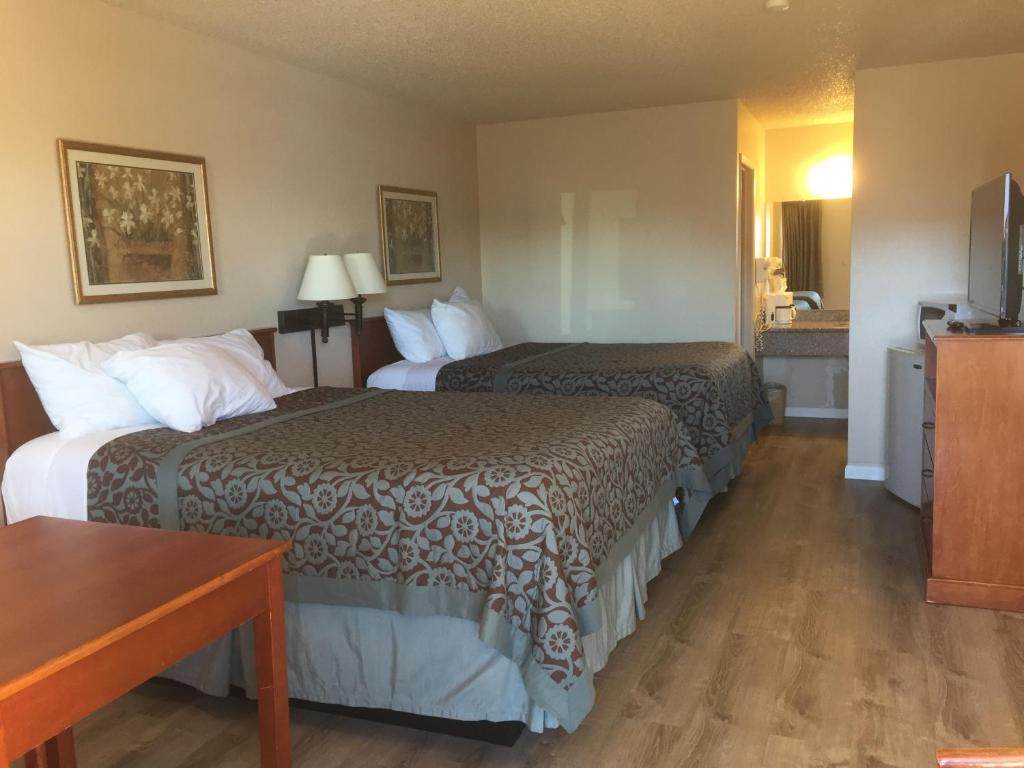a hotel room with two beds and a table at Travel Inn - Mesa in Mesa