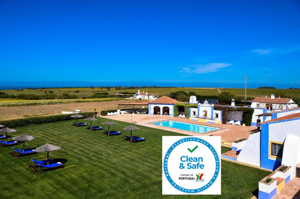 un complexe avec une piscine et un panneau pour un spa dans l'établissement Herdade Do Touril, à Zambujeira do Mar