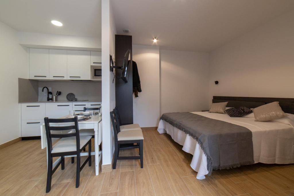 a bedroom with a bed and a desk and a kitchen at Loft en Zarautz con Parking Hator 2 in Zarautz