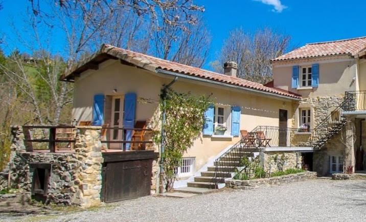 una casa grande con una puerta y escaleras delante en Gite Les genêts, baronnies provençales, en Montjay