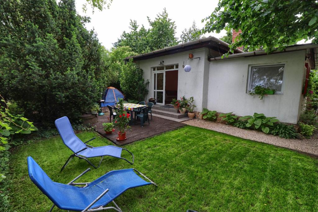 a yard with two chairs and a table and a house at Family Cottage in Gárdony