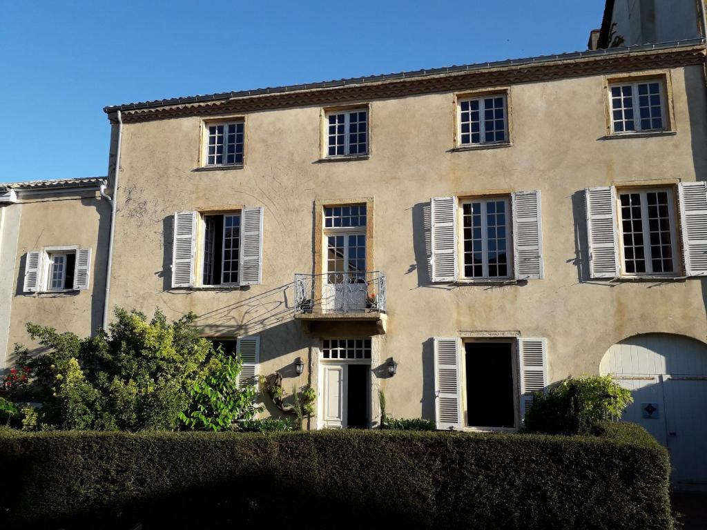 an old building with white shutters on it at La Chanoinesse in Salles-Arbuissonnas