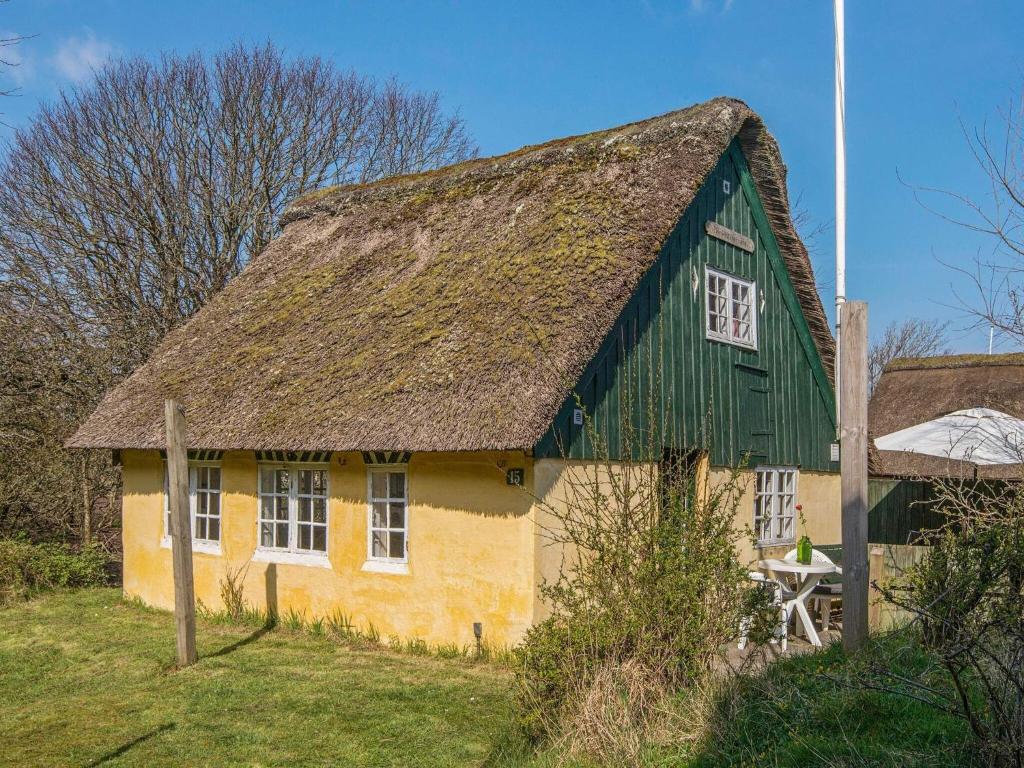 een geel en groen huis met een grasdak bij 4 person holiday home in Fan in Fanø