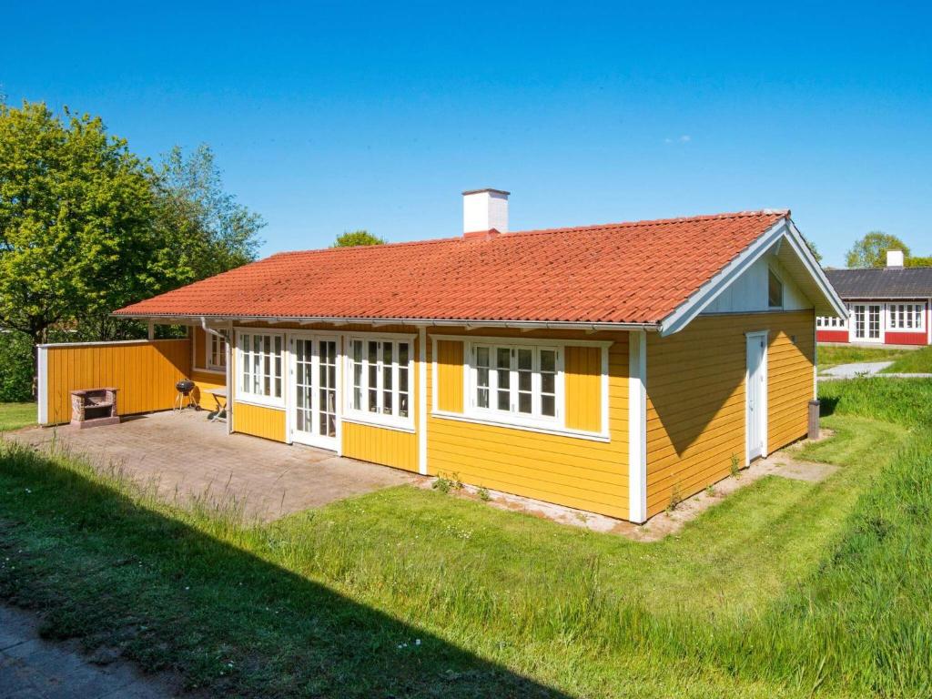 mały żółty dom z pomarańczowym dachem w obiekcie Three-Bedroom Holiday home in Aabenraa 6 w mieście Danland Løjt