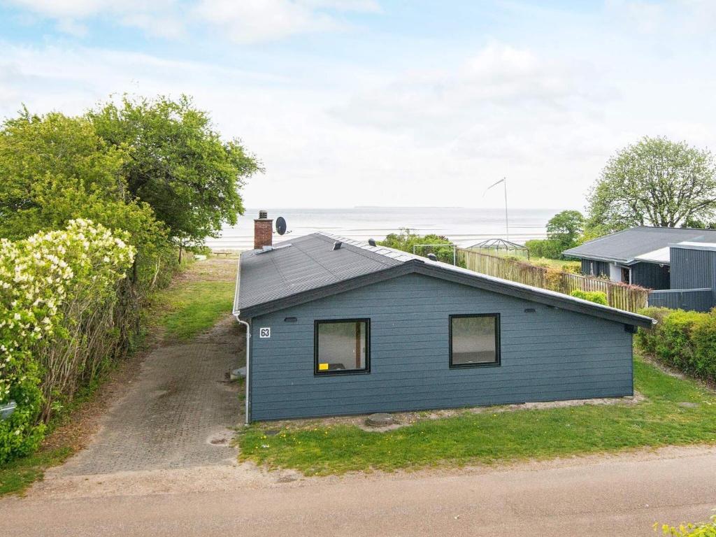 una casa azul sentada al costado de un camino en 6 person holiday home in Bjert, en Binderup Strand
