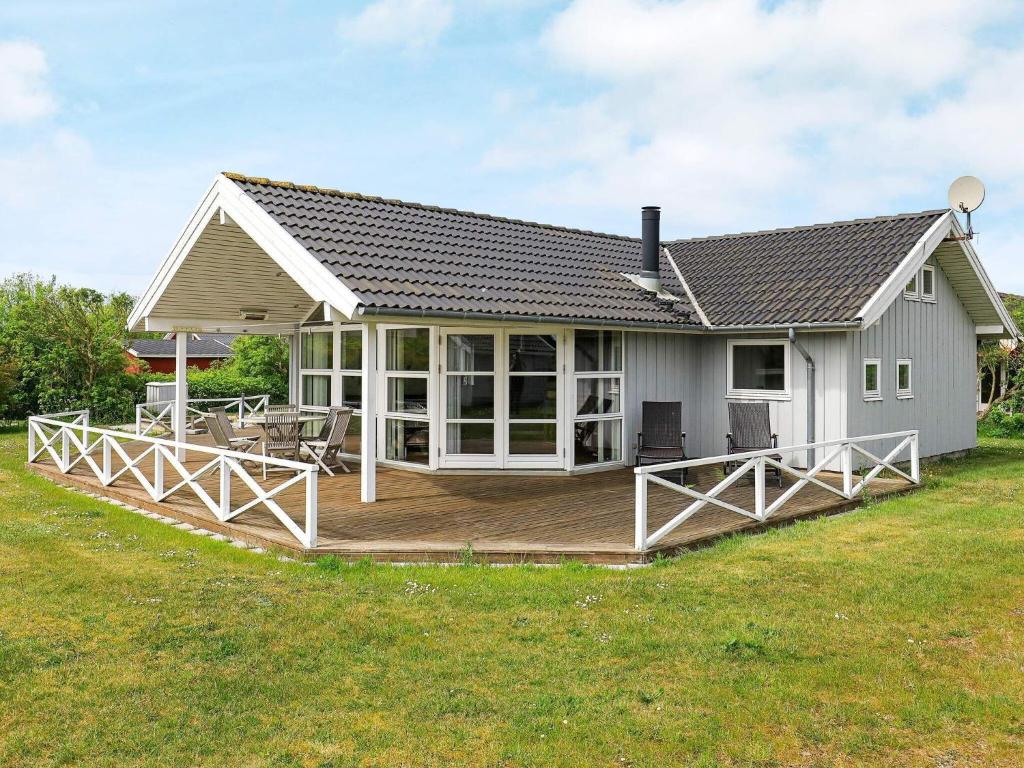 une maison avec une grande terrasse dans la cour dans l'établissement 8 person holiday home in Lemvig, à Lemvig