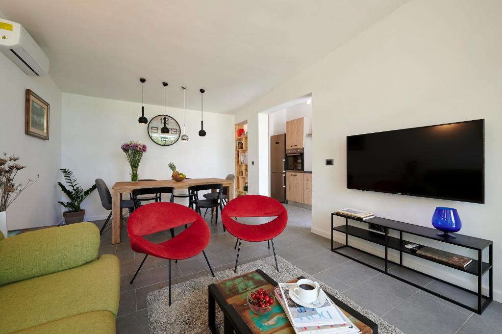 sala de estar con sofá y mesa con sillas rojas en Villa Lovor en Trogir