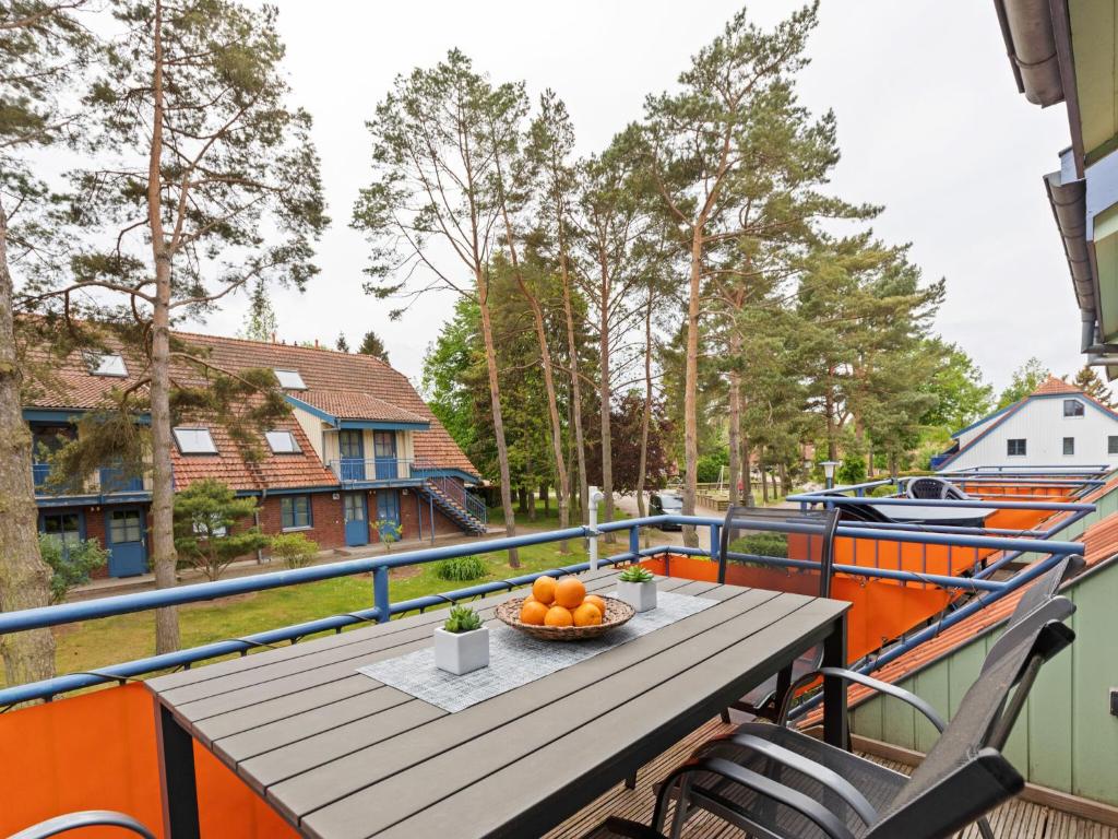 einen Tisch auf einem Balkon mit einer Schüssel Orangen in der Unterkunft Spacious Apartment in Boltenhagen by the Sea in Boltenhagen