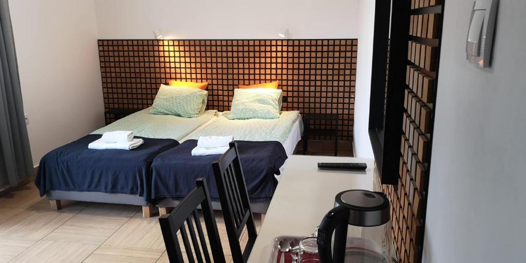 a bedroom with two beds with blue sheets and pillows at Gościniec Celina in Krasnobród
