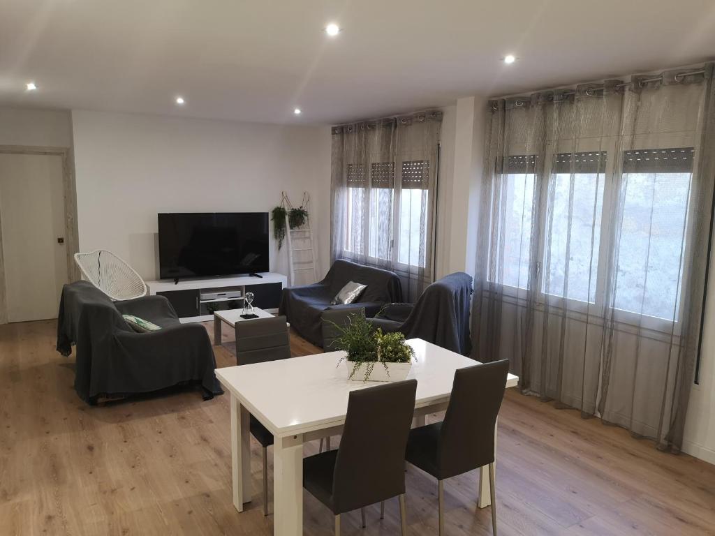a living room with a table and chairs and a tv at Casa Serral in Deltebre