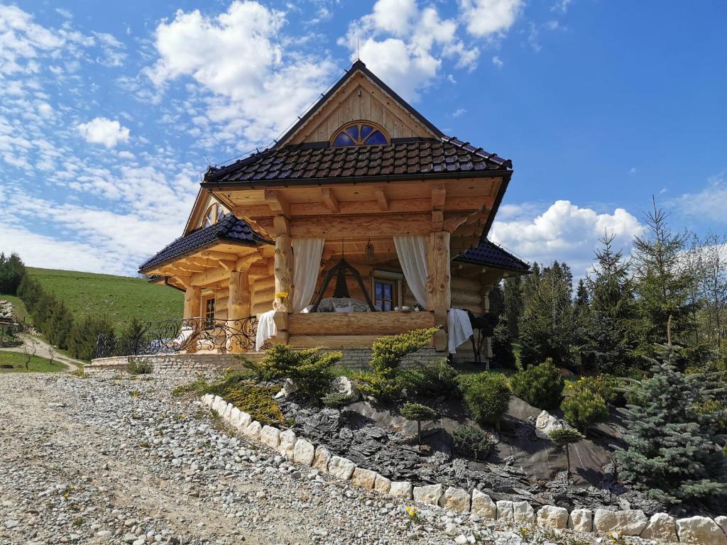 a log cabin with a gambrel roof at Sielanka z gorącą banią na wyłączność in Łapsze Niżne