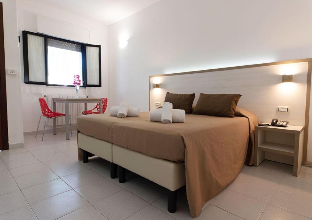 a bedroom with a large bed and a red chair at Hotel Residence Nemo in Brindisi