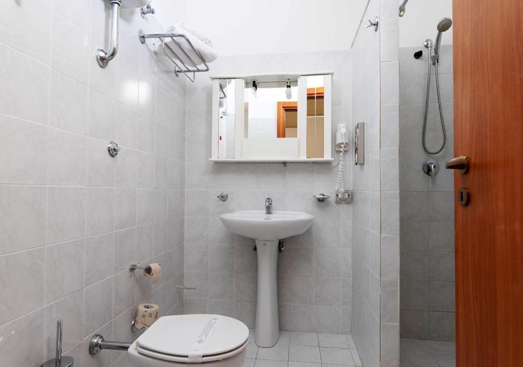 a bathroom with a sink and a toilet and a mirror at Hotel Residence Nemo in Brindisi