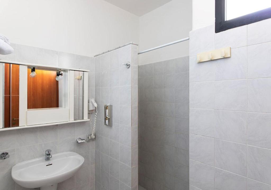 a white bathroom with a sink and a mirror at Hotel Residence Nemo in Brindisi