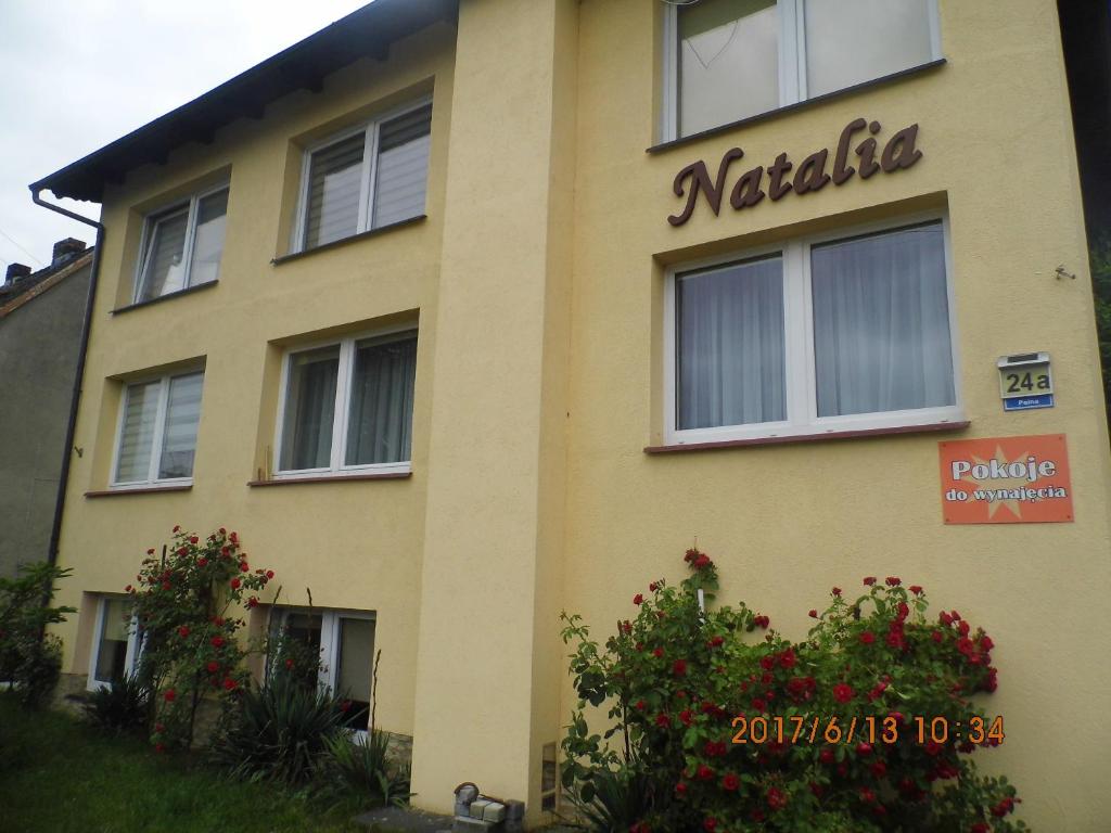 a yellow building with a sign on the side of it at Pokoje gościnne NATALIA in Międzyzdroje