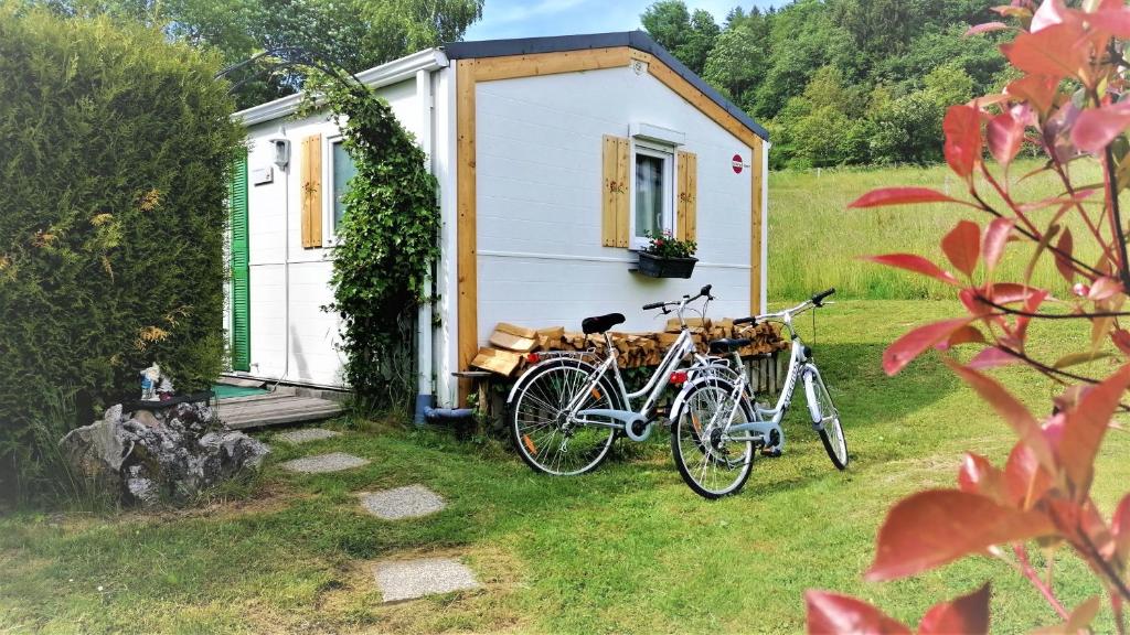 duas bicicletas estacionadas em frente a uma pequena casa em Holiday home Rozika em Slovenj Gradec