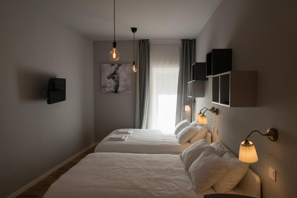 a hotel room with two beds and a window at SMILE&LOVE REPUBLIC ZAGREB CENTER in Zagreb