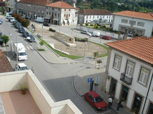 a red car parked in a parking lot in a town at Ares Vieira in Vieira do Minho
