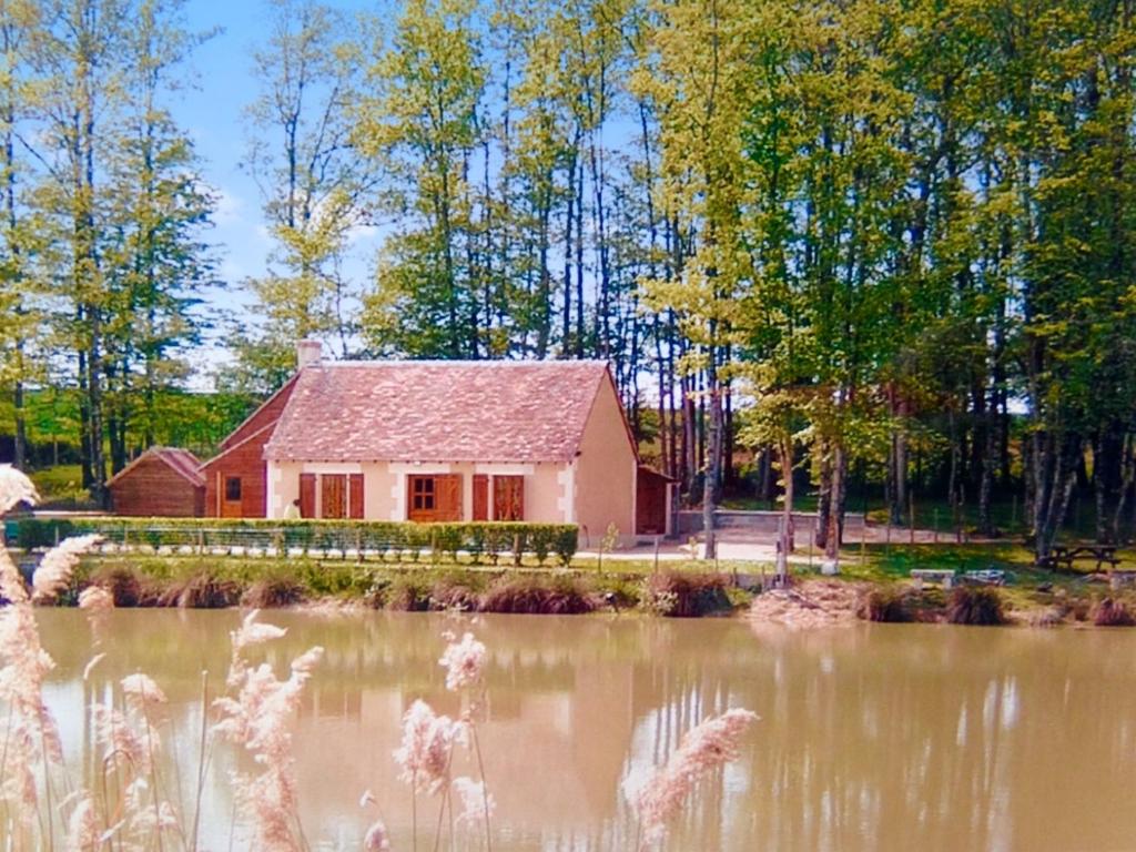 FaverollesにあるMaison de 3 chambres avec vue sur le lac piscine partagee et jardin clos a Villentrois Faverolles en Berryの池のある赤い家