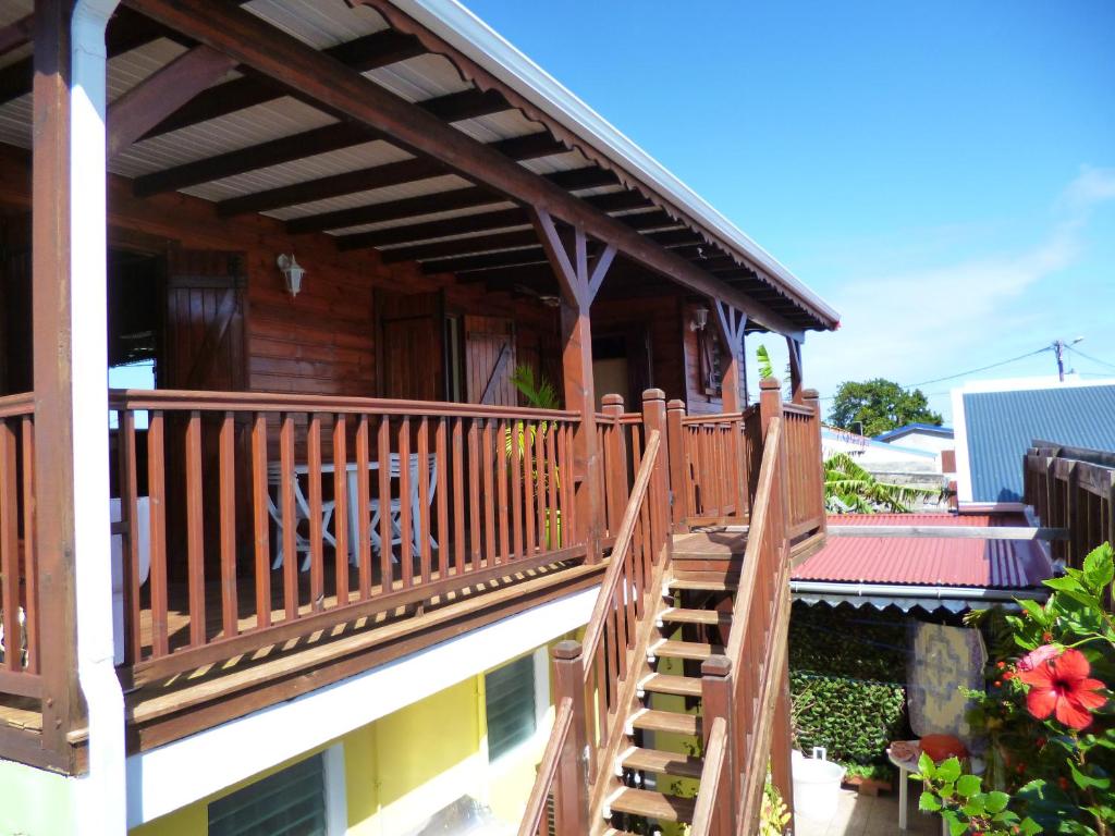 una escalera de madera que conduce a una casa con balcón en Chalet d'une chambre avec terrasse amenagee et wifi a Le Moule a 3 km de la plage, en Le Moule