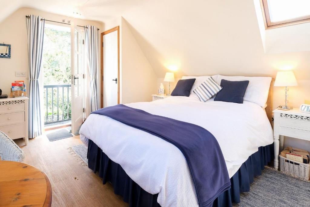 Un dormitorio con una gran cama blanca y una ventana en The Bay Tree Studio en Thorpeness