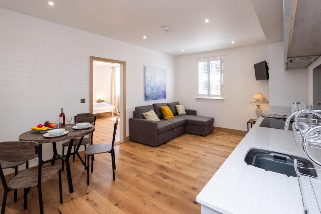 a kitchen and living room with a couch and a table at Three Tuns Apartments - Hazel in Pettistree