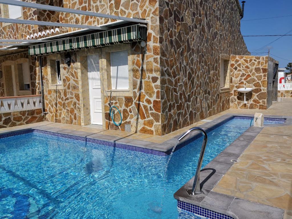 - une piscine en face d'un bâtiment en pierre dans l'établissement Residencia Thomas, à Dénia