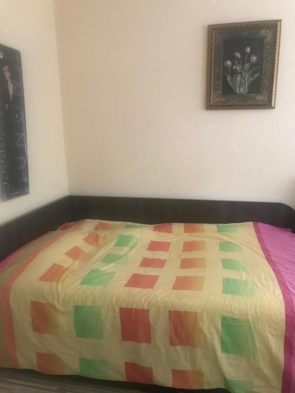 a bed with a colorful quilt on it in a room at House 1 in Dimitrovgrad