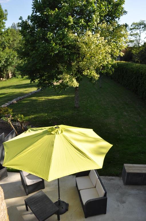 un gran paraguas amarillo sentado en un patio en Gite Ti Maen, en Sulniac
