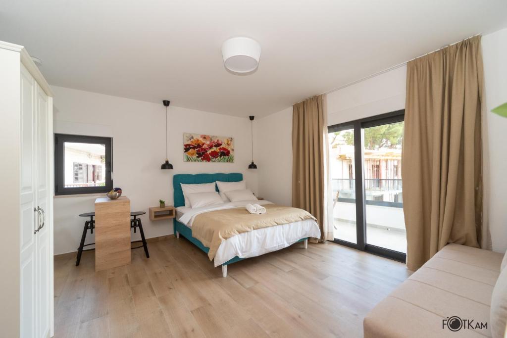 a bedroom with a bed and a desk in it at Libar Studio Apartments in Baška Voda