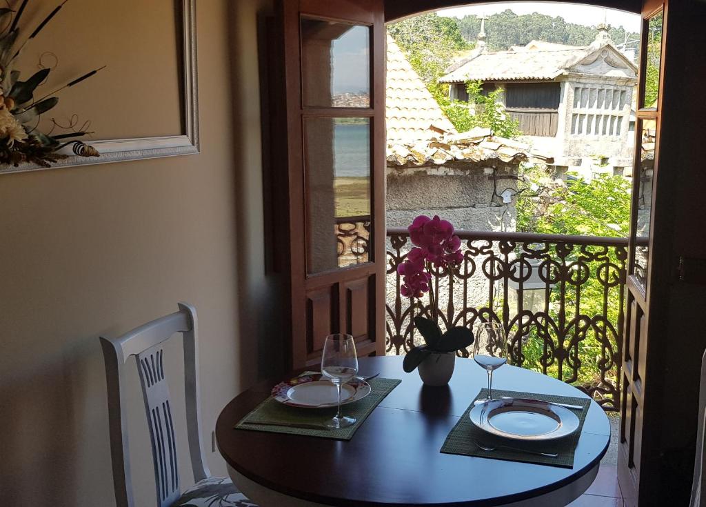 a dining room table with a view of a balcony at Atico Mirador Rualeira in Combarro