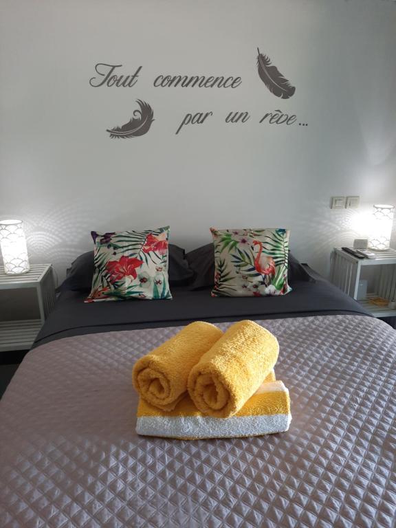 a bed with two towels and a piece of bread at Little home Tahiti in Papeete