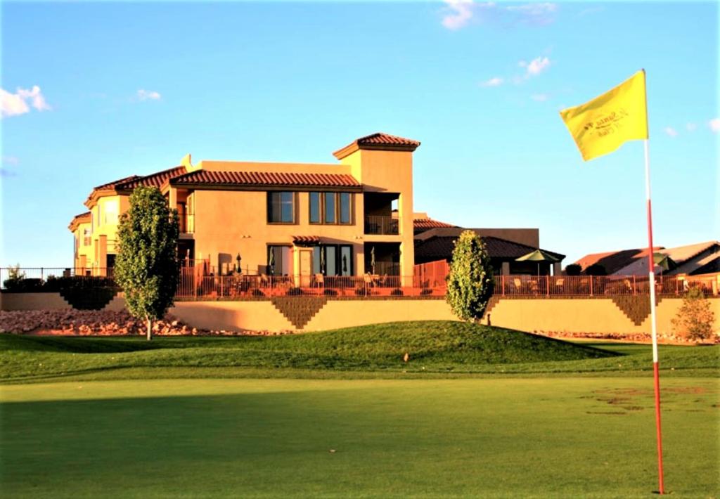 uma casa num campo de golfe com uma bandeira amarela em Highlands Resort at Verde Ridge em Cottonwood