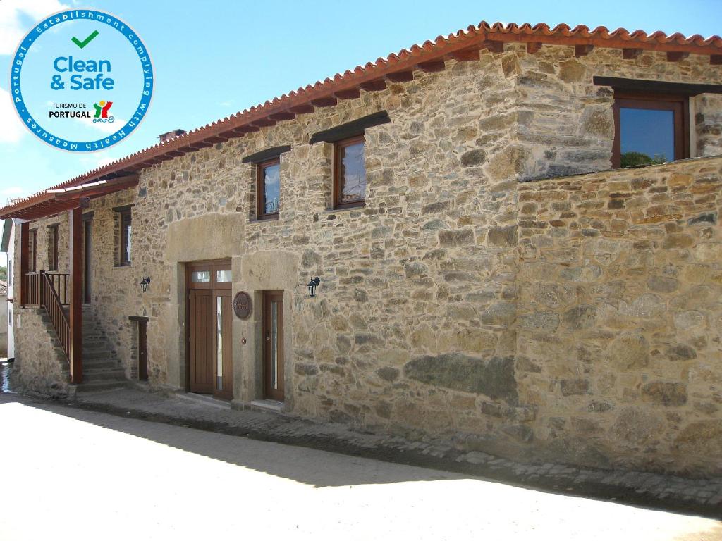 a stone house with a sign that says clean safe at Candeias do Souto in Bragança