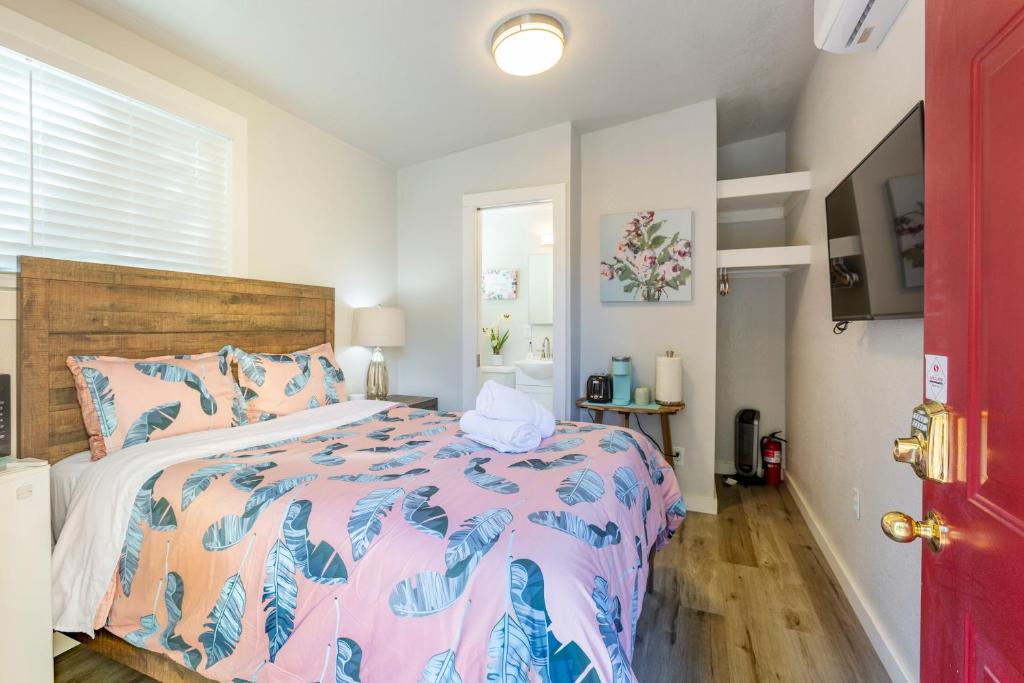 a bedroom with a bed with a pink and blue comforter at @ Marbella Lane Mini Guest House in Downtown San Jose in San Jose