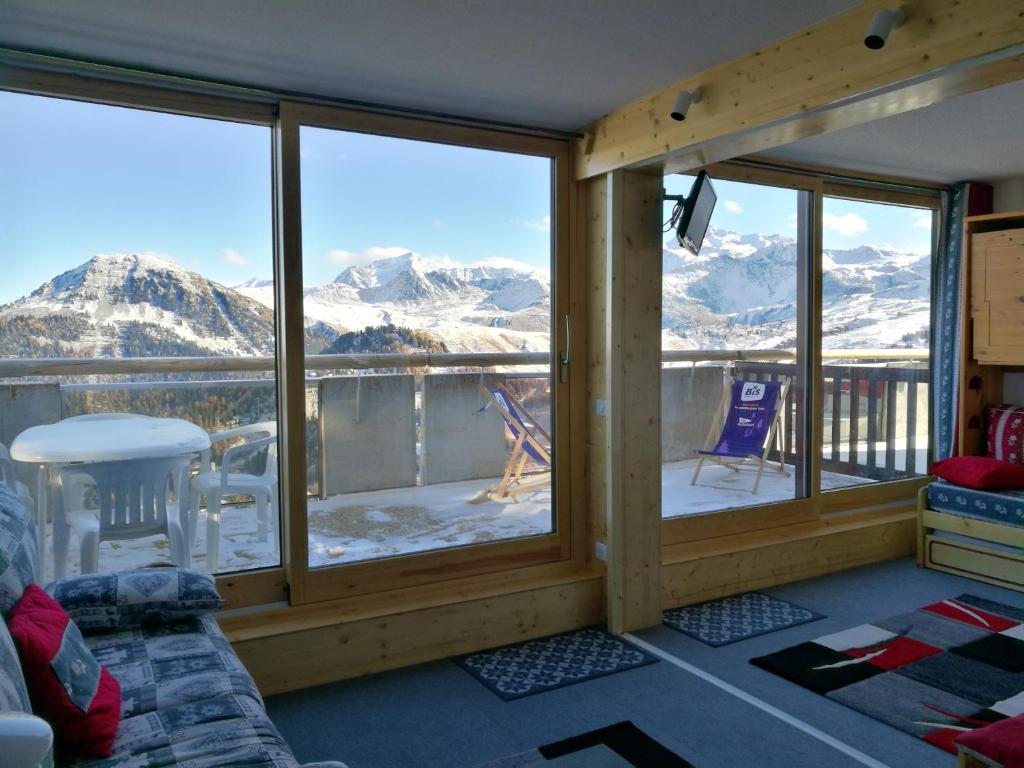 une véranda avec vue sur les montagnes enneigées dans l'établissement Appartement convivial à La Plagne - 28 m² avec vue sur la montagne, à Mâcot La Plagne