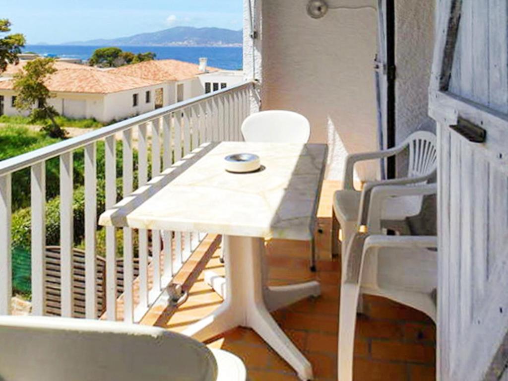 ポルティシオにあるAppartement d'une chambre a Grosseto Prugna a 50 m de la plage avec vue sur la mer et jardin closの白いテーブルと椅子付きのバルコニー