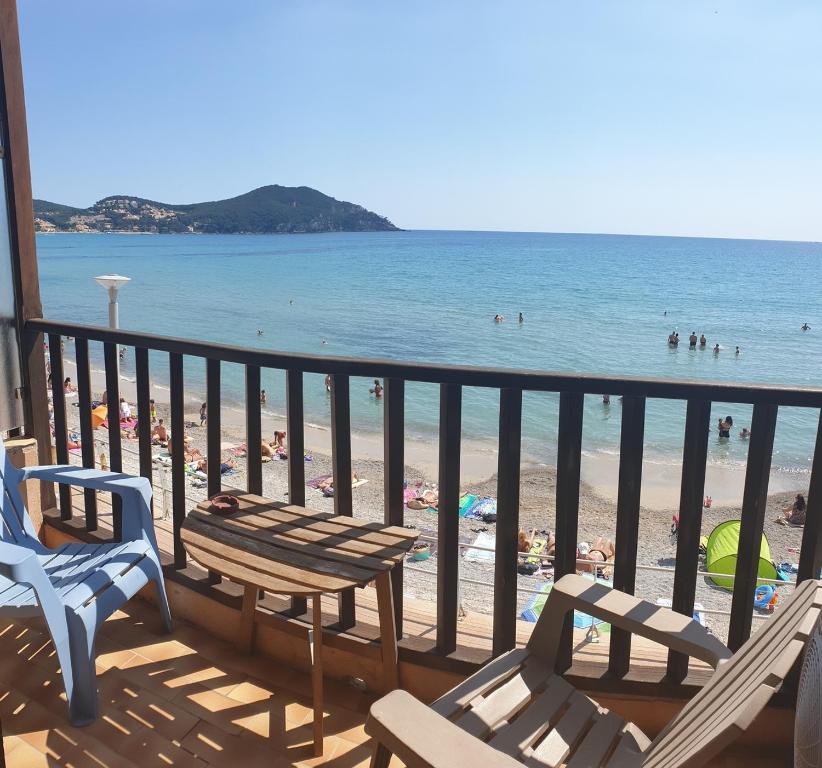 a balcony with a table and chairs and the beach at Hotel Chanteplage in Saint-Cyr-sur-Mer