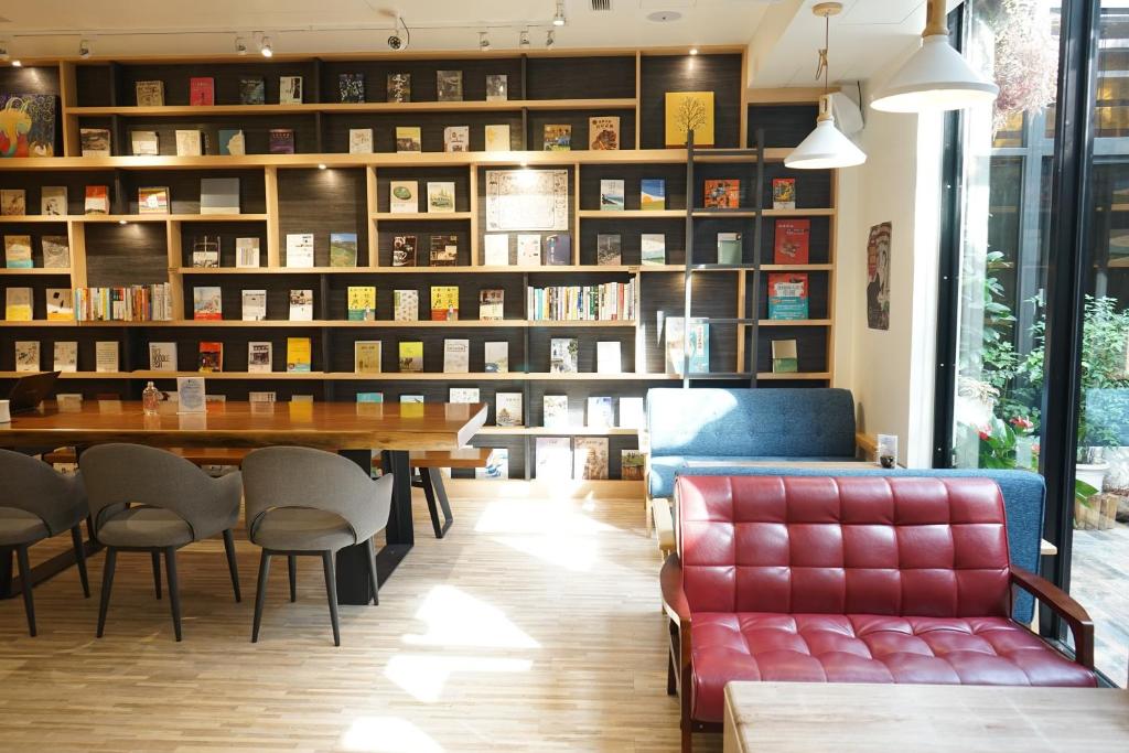 a library with a table and chairs and bookshelves at Hangkhau Hotel in Yilan City